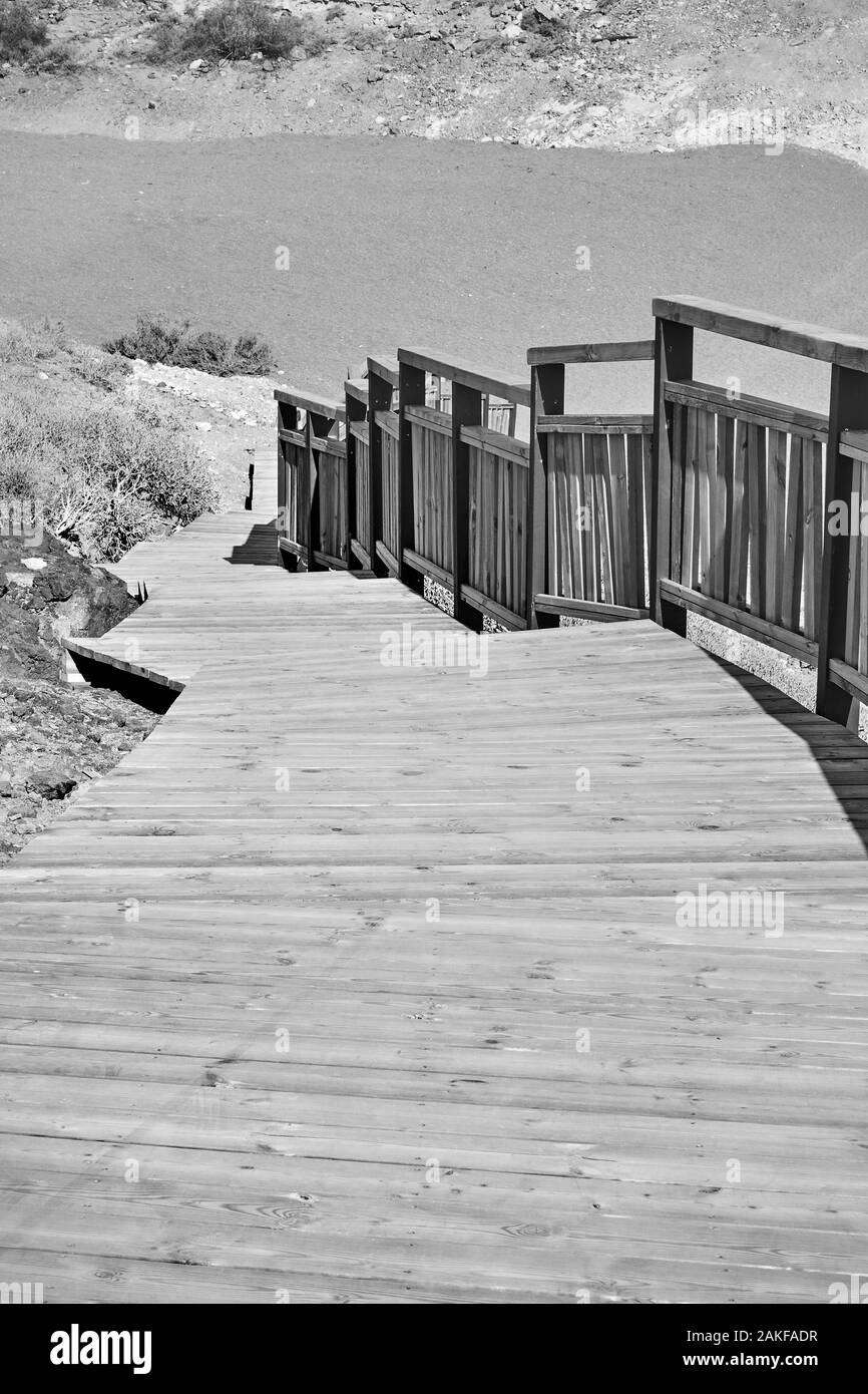 Sentier en bois avec garde-corps sur la plage. Image en noir et blanc Banque D'Images