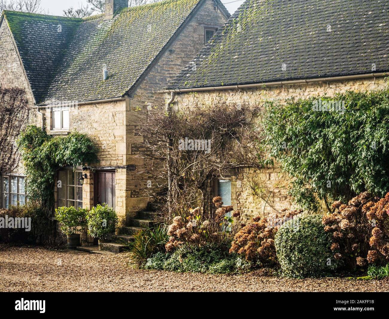 Quelques jolies maisons en pierre dans le village de Cotswold Hampnet dans le Gloucestershire. Banque D'Images