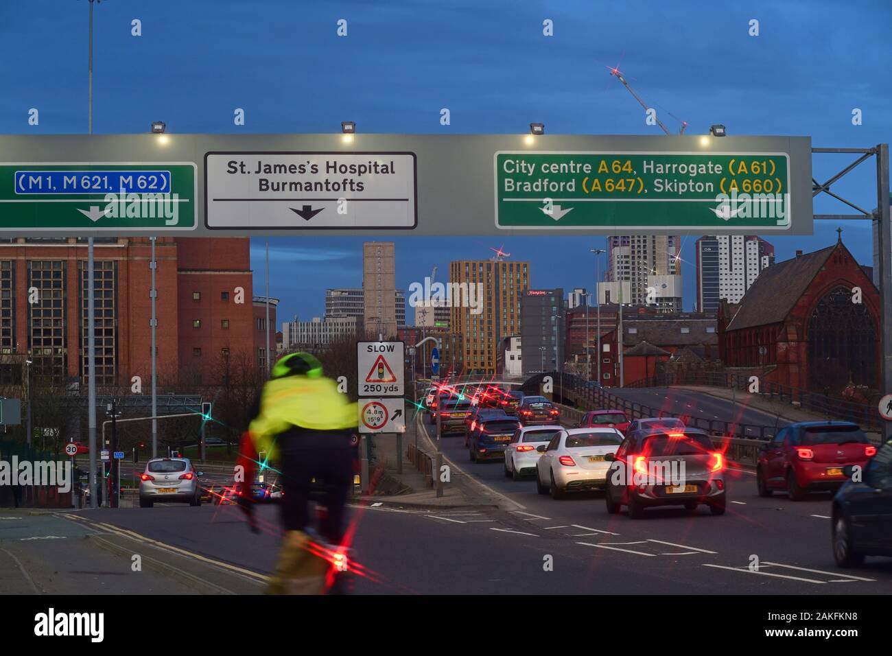 Circonscription cycliste passé embouteillage queuing dans la ville de ledds au crépuscule yorkshire royaume uni Banque D'Images