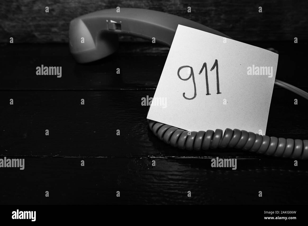 L'écriture 911 Note sur du papier collant. rappel post entouré de fil de téléphone fixe. Banque D'Images