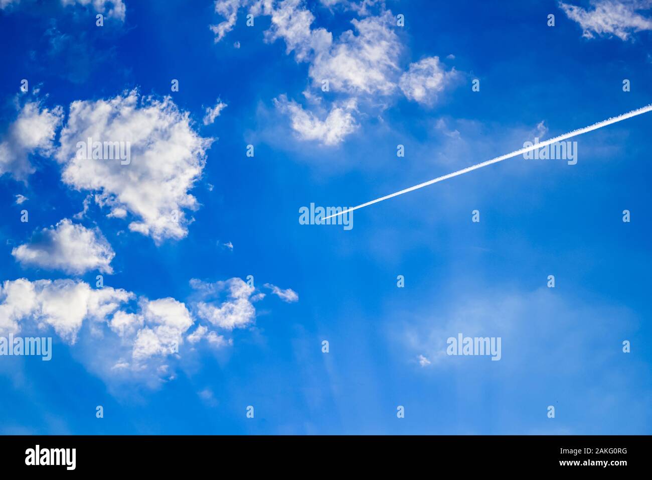 Avion à grande altitude dans un ciel bleu clair avec des nuages Banque D'Images