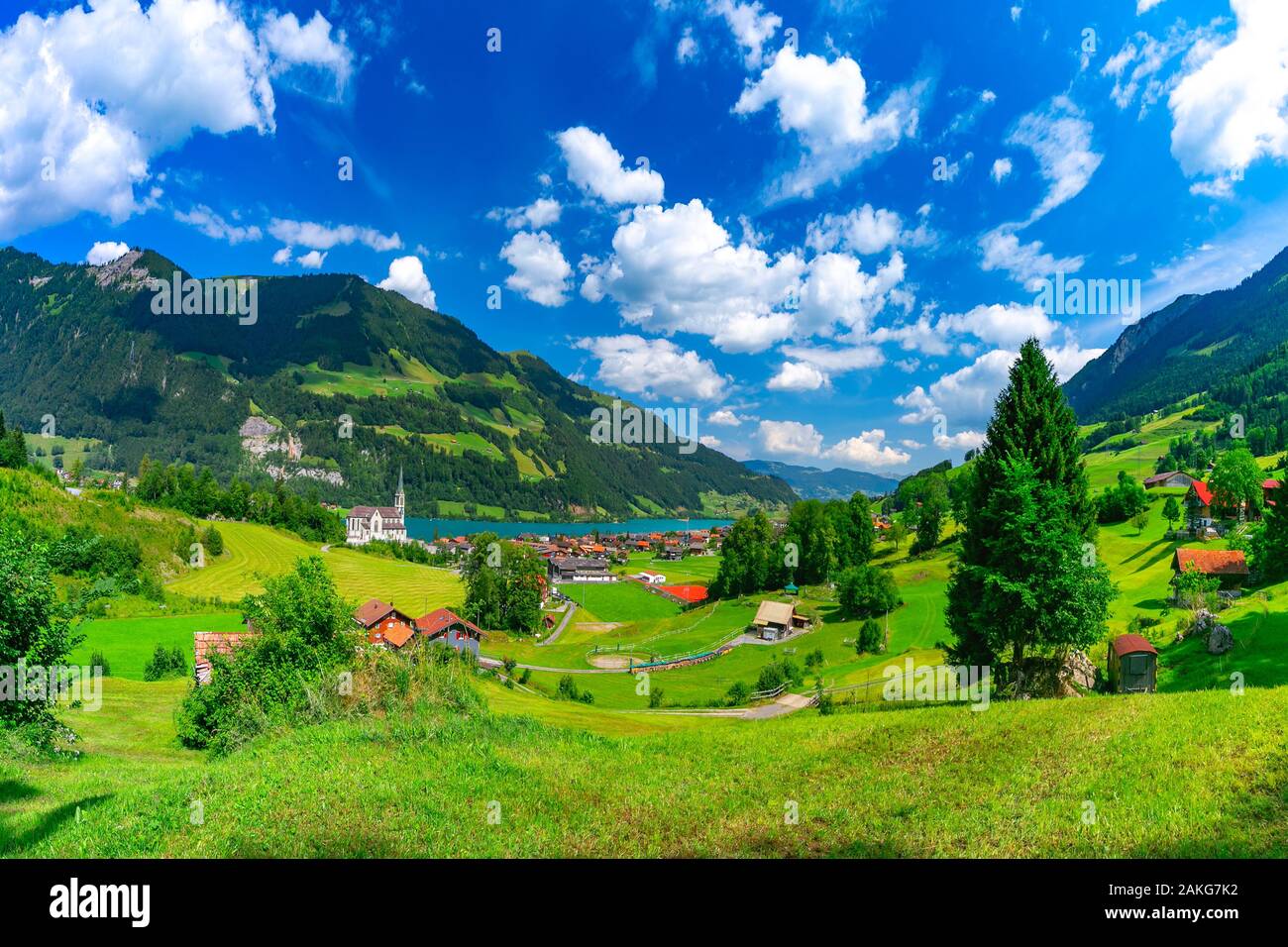 L'église catholique traditionnelle, bois et maisons modernes le long du lac Lungernsee dans swiss village Lungern en journée ensoleillée, Obwalden, Suisse Banque D'Images