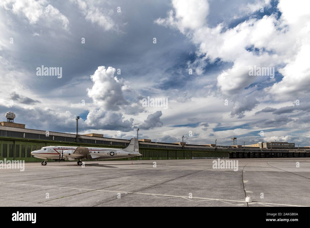 Vue grand angle du terminal de l'aéroport de Tempelhof à Berlin, sous un ciel orageux et avec un USAF DC4 désaffecté en premier plan Banque D'Images