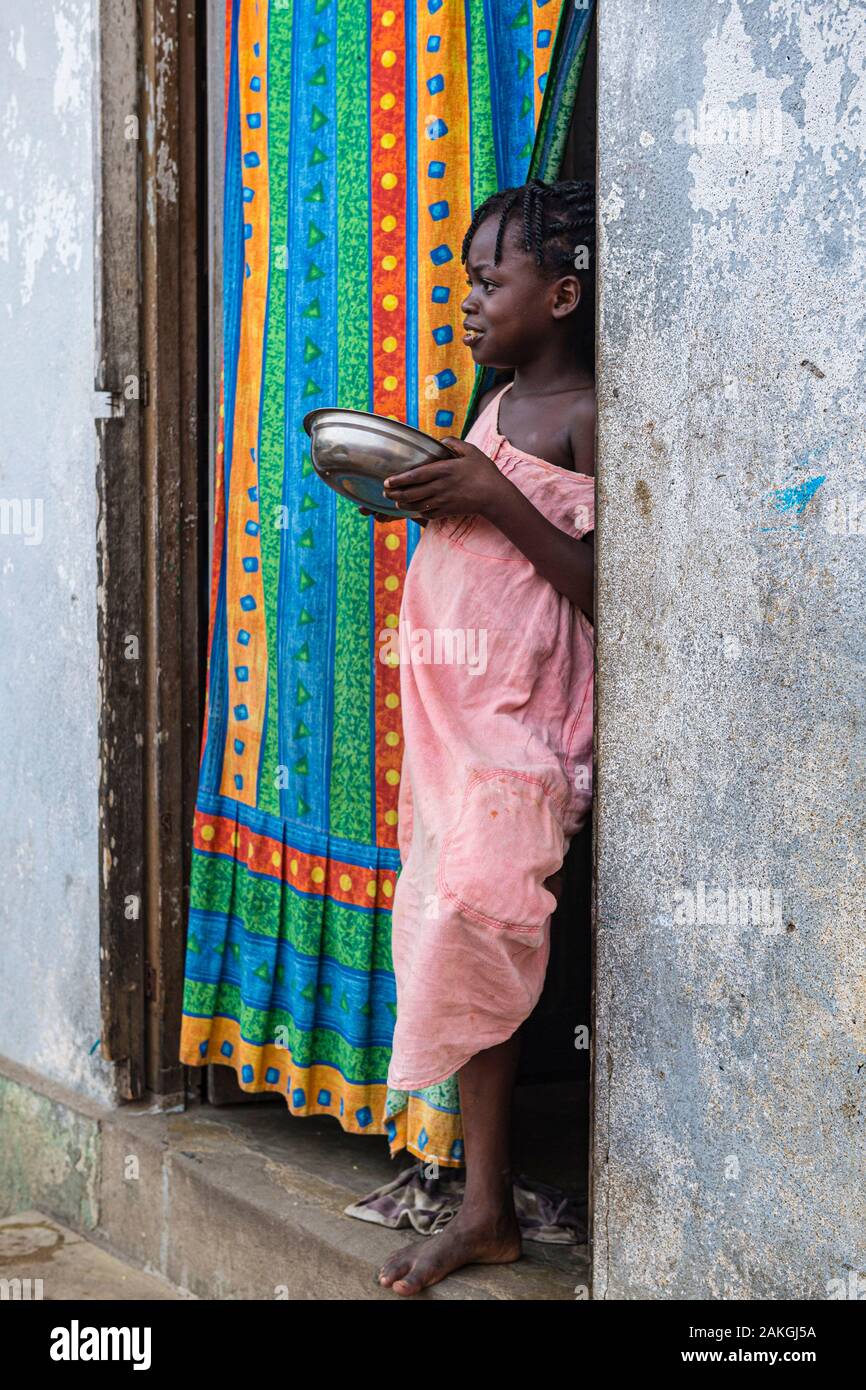 Côte d'Ivoire, Grand Bassam, jeune fille debout à la porte de sa maison Banque D'Images