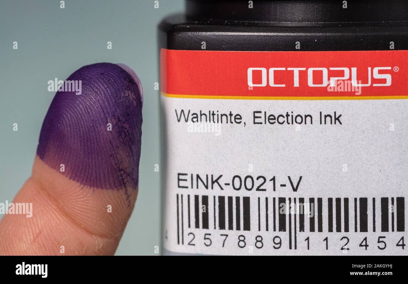 Dresde, Allemagne. Dec 18, 2019. Un chimiste de l'Fabricant d'encre basée à Dresde le poulpe détient son index imbibé d'encre choix à côté d'un pot de peinture. La peinture spéciale sur le doigt est destiné à prévenir la fraude électorale, par exemple dans les prochaines élections en Iraq. Crédit : Robert Michael/dpa-Zentralbild/ZB/dpa/Alamy Live News Banque D'Images