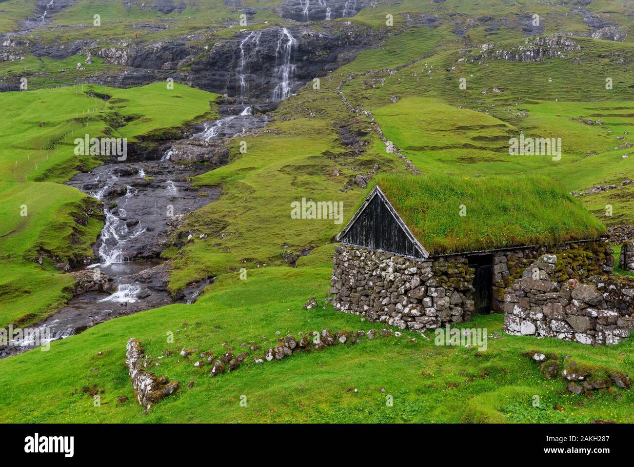 Le Danemark, îles Féroé, de l'île de Streymoy, Saksun Village, bâtiment de ferme et de la chute d'eau dans l'arrière-plan Banque D'Images