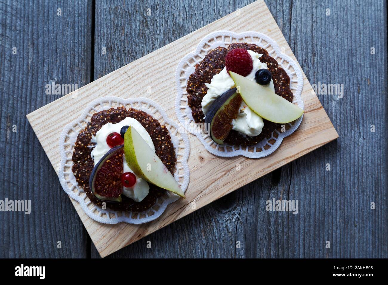 Biscuits garnie de crème et de fruits de saison. Ils sont servis sur des napperons. Banque D'Images