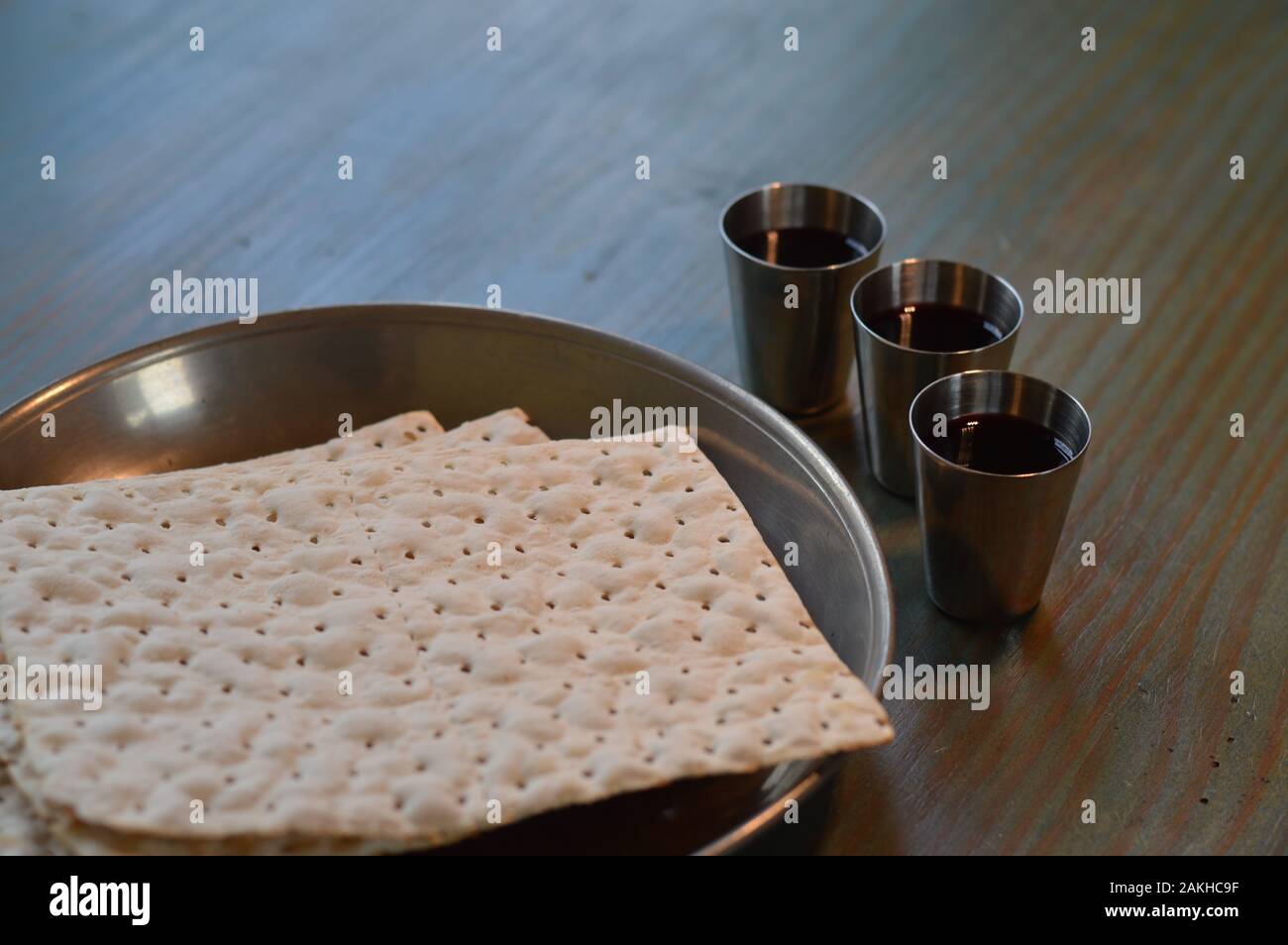 Le dîner du Seigneur avec du pain sur une assiette de étain et trois petites tasses de vin Banque D'Images