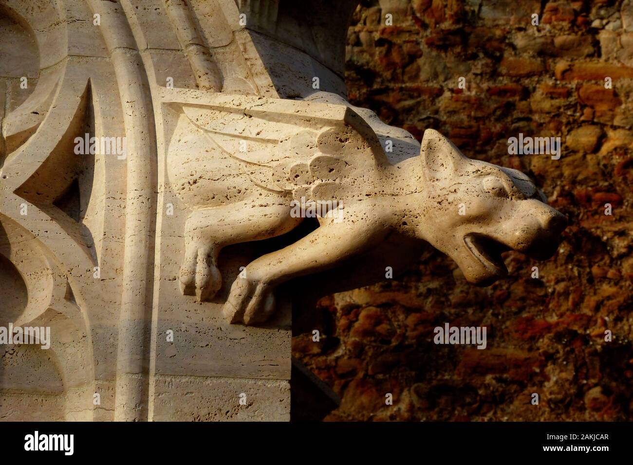 Brillant beige claire gargouille de pierre et boiserie de la fenêtre en face du mur extérieur en brique et pierre fine. arrière-plan ciselé et lion ailé statue de forme Banque D'Images