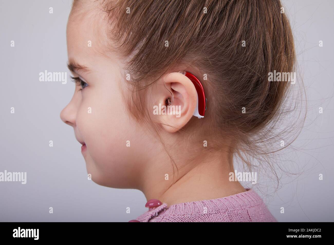 Prothèse auditive dans l'oreille de la jeune fille. Petite fille portant un appareil  auditif. Prise de vue en studio Photo Stock - Alamy