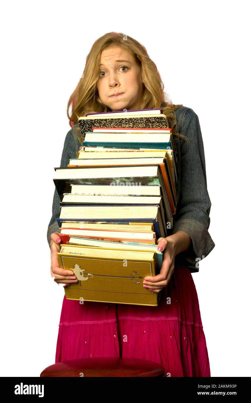 Femme Caucasian student avec une lourde pile de manuels scolaires Banque D'Images