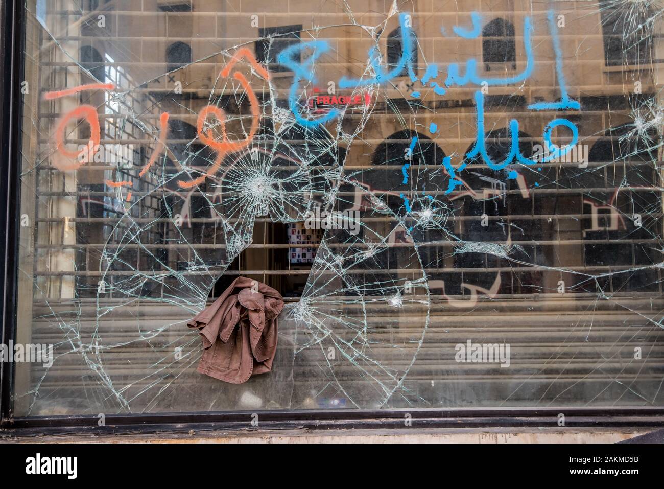 Vitrine vandalisée et brisé, et une veste marron laissés derrière. Banque D'Images