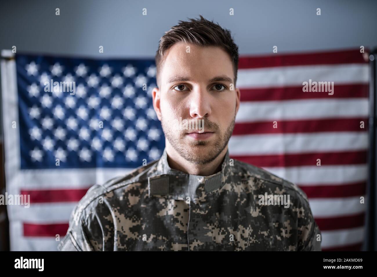 Portrait de soldat grave standing in front of Us Flag Banque D'Images