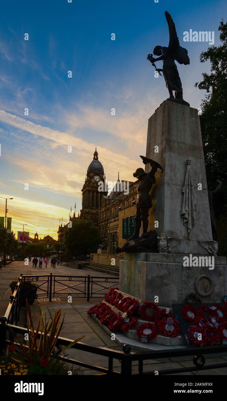 Le monument commémoratif de guerre dans le centre-ville de Leeds avec des couronnes de coquelicots et de Leeds Town Hall au-delà. Banque D'Images