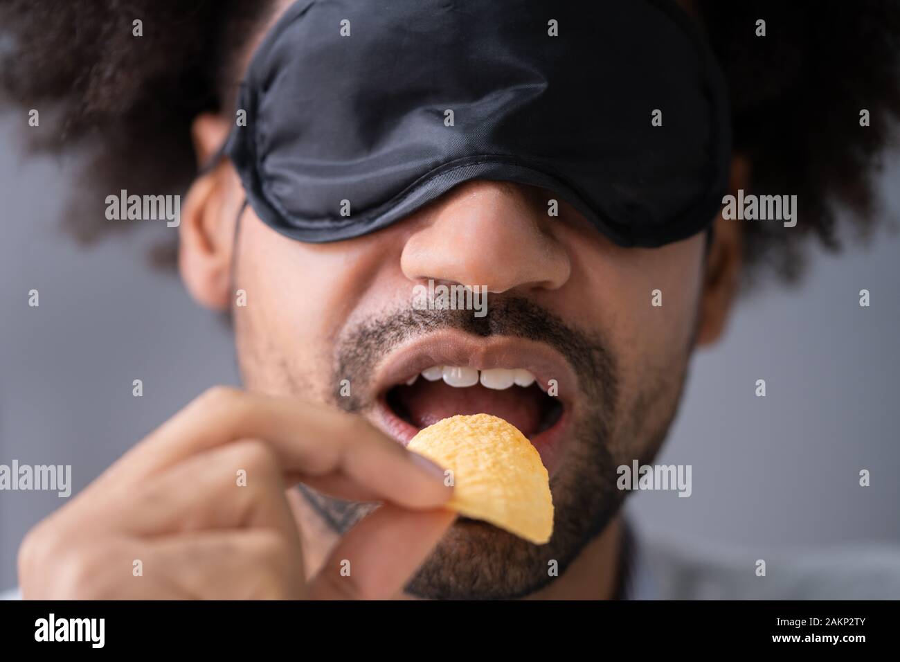 Portrait de jeune homme, les yeux bandés, l'alimentation à l'essai Banque D'Images