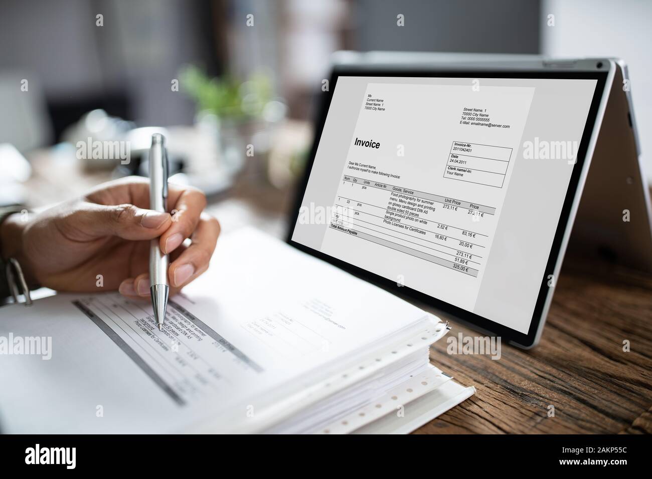 Close-up of Woman's Hands travaillant sur facture sur Laptop At Office Banque D'Images