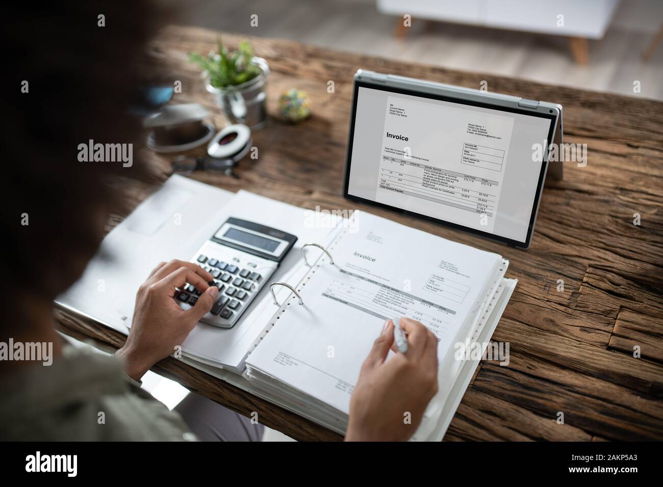 Close-up of Woman's Hands travaillant sur facture sur Laptop At Office Banque D'Images