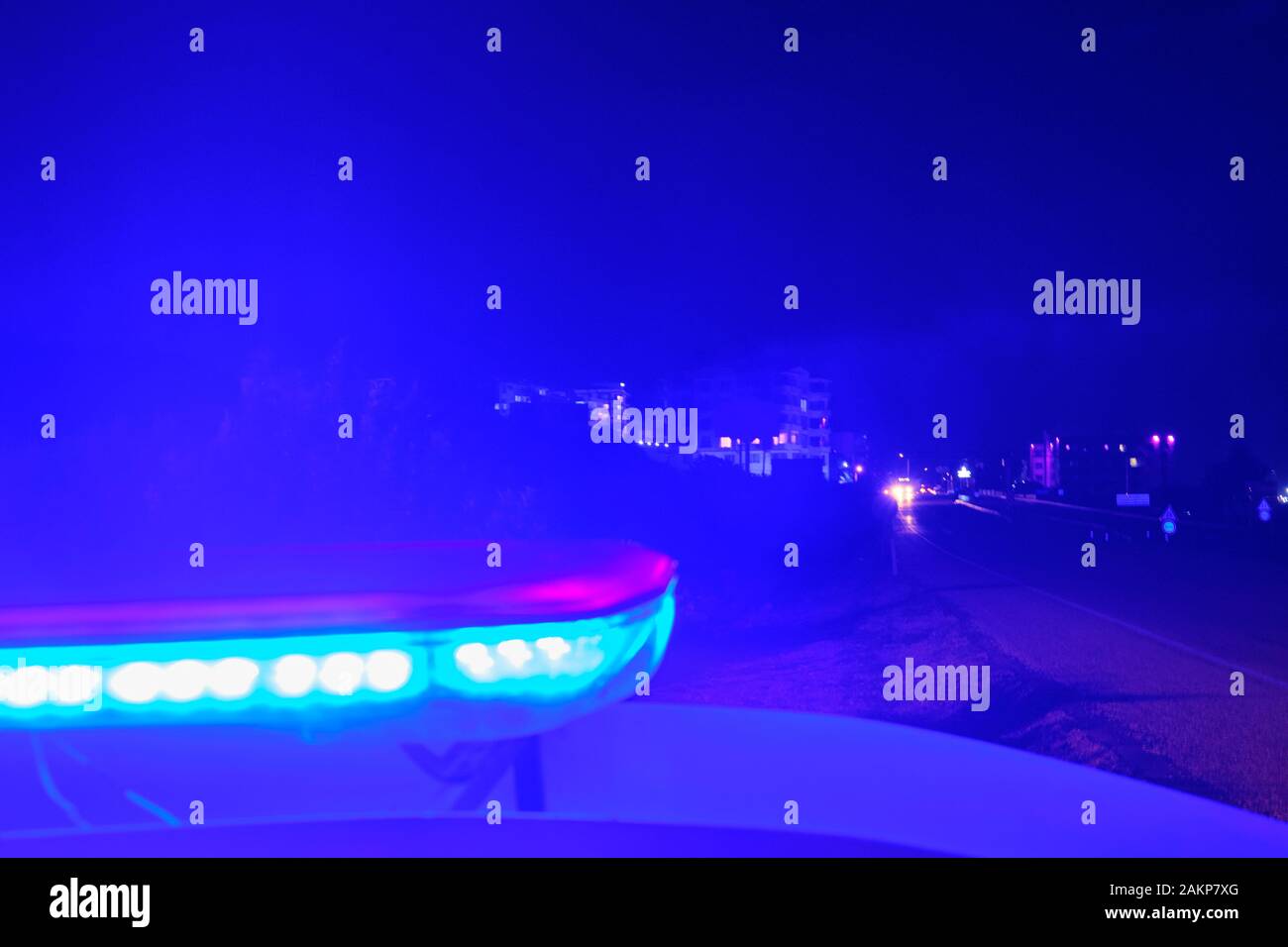 Voiture de police des lumières clignotantes dans la nuit focus sélectif. Banque D'Images