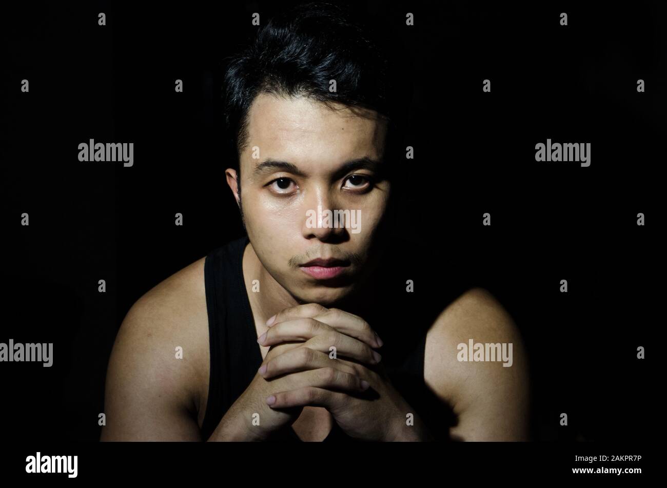 portrait de jeune homme asiatique en lumière sombre Banque D'Images