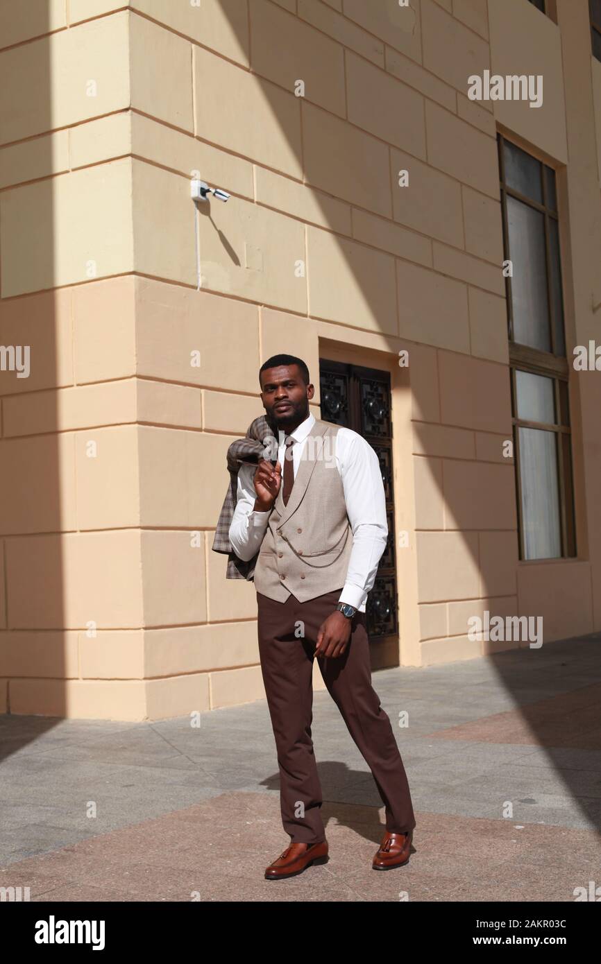 Portrait du corps complet du modèle de mode masculin d'afrique à pied et dans un costume marron. Style luxueux et cher look d'affaires, bien habillé gentleman Banque D'Images