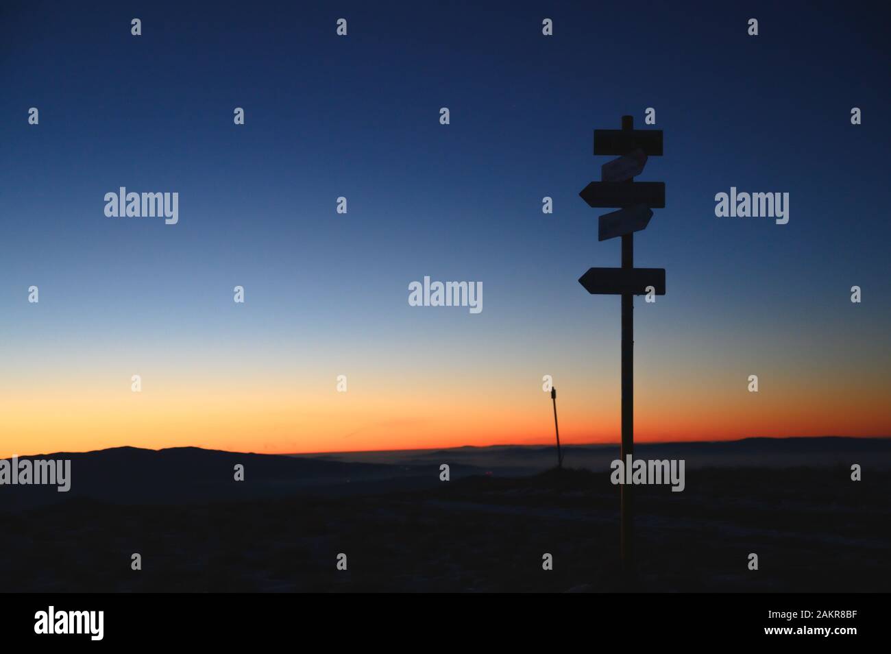 Silhouette de flèches dans les montagnes, lumière du lever du soleil en arrière-plan. Flèches indiquant la direction droite. Banque D'Images