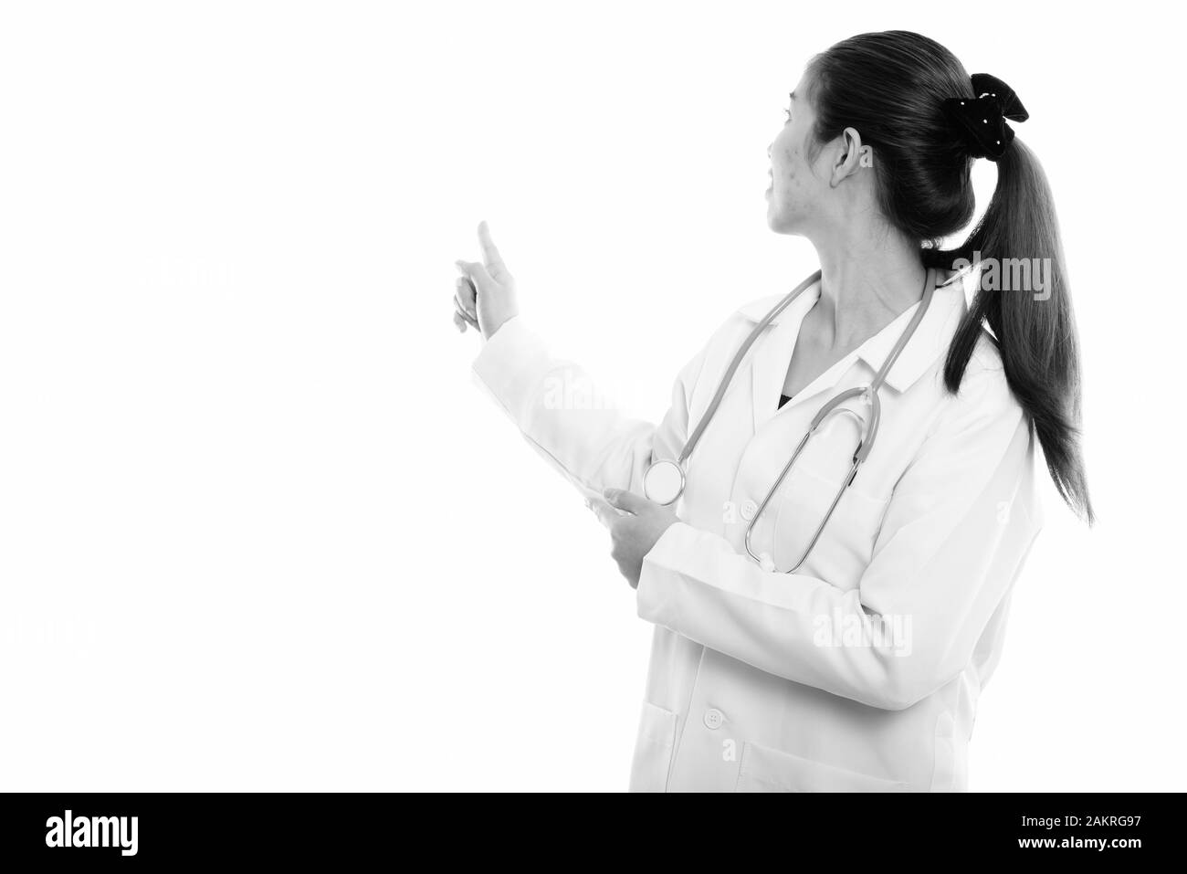 Vue arrière de Young Asian woman doctor montrant quelque chose sur le mur Banque D'Images