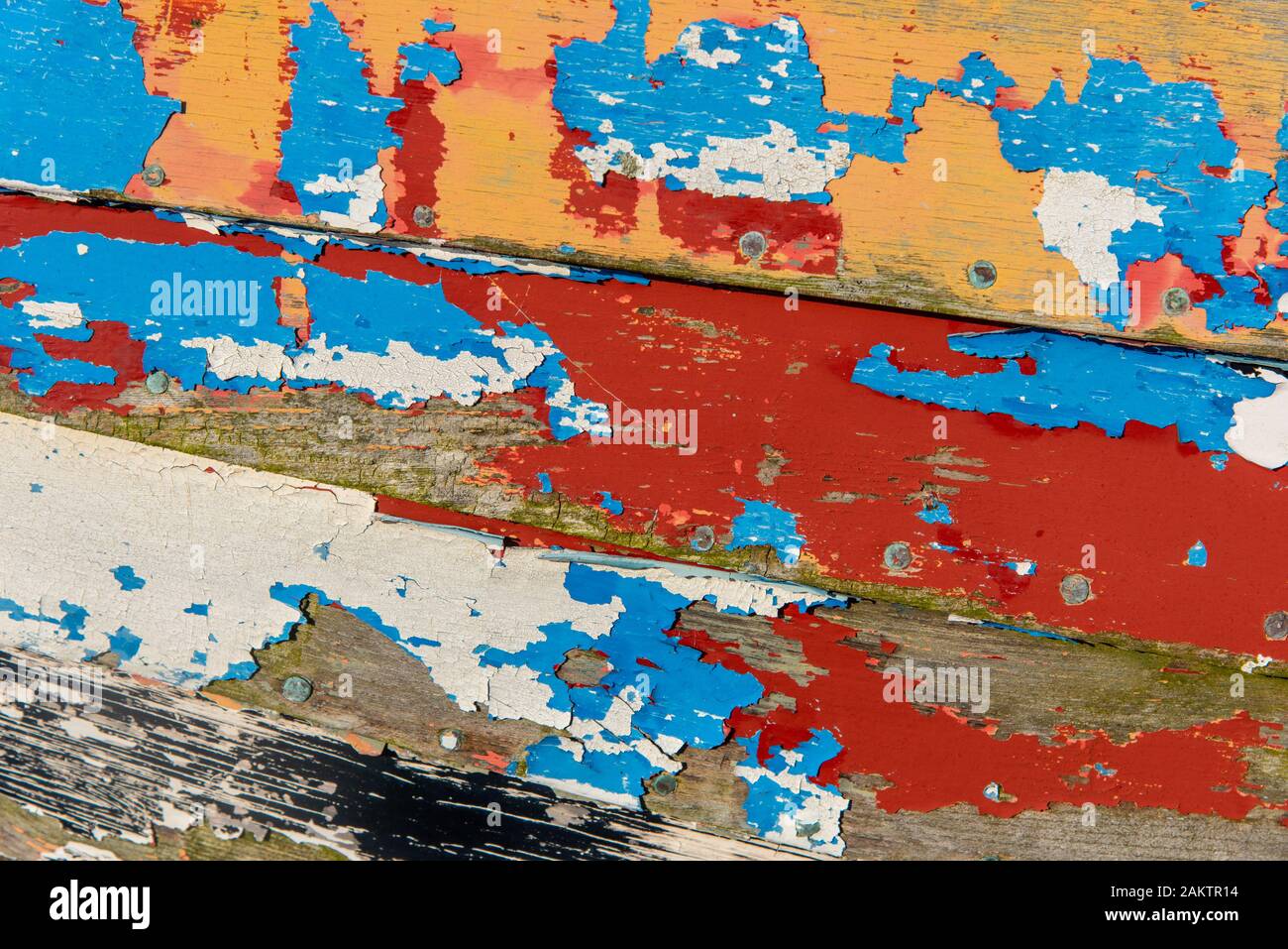 Abstraite de la côté d'un bateau de pêche en bois montrant de nombreuses couches de peinture altérée. Banque D'Images