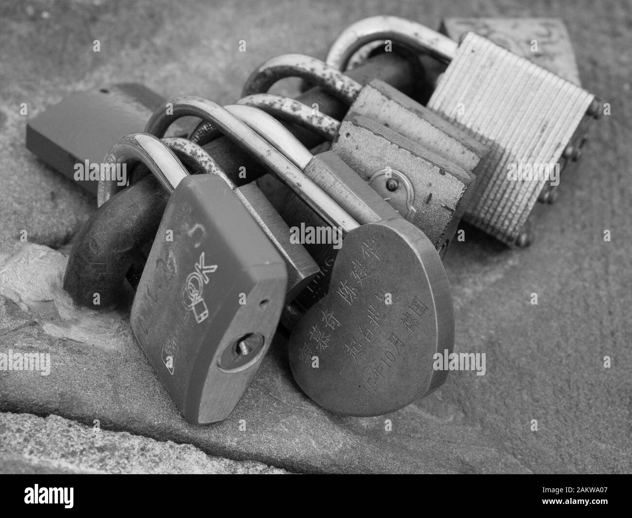 Close-up de plusieurs serrures avec amour écrit en caractères chinois au vieux pont à Heidelberg, Allemagne en noir et blanc Banque D'Images