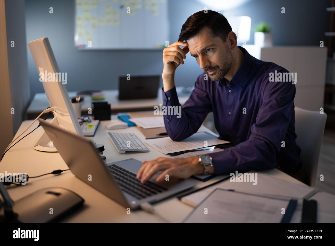 Comptable a souligné assis avec tête en main en travaillant à la fin de l'Office de Tourisme Banque D'Images
