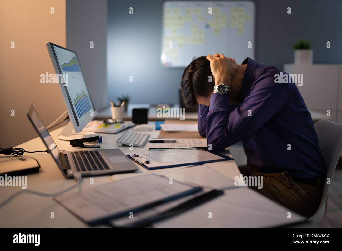 Comptable a souligné assis avec tête en main en travaillant à la fin de l'Office de Tourisme Banque D'Images