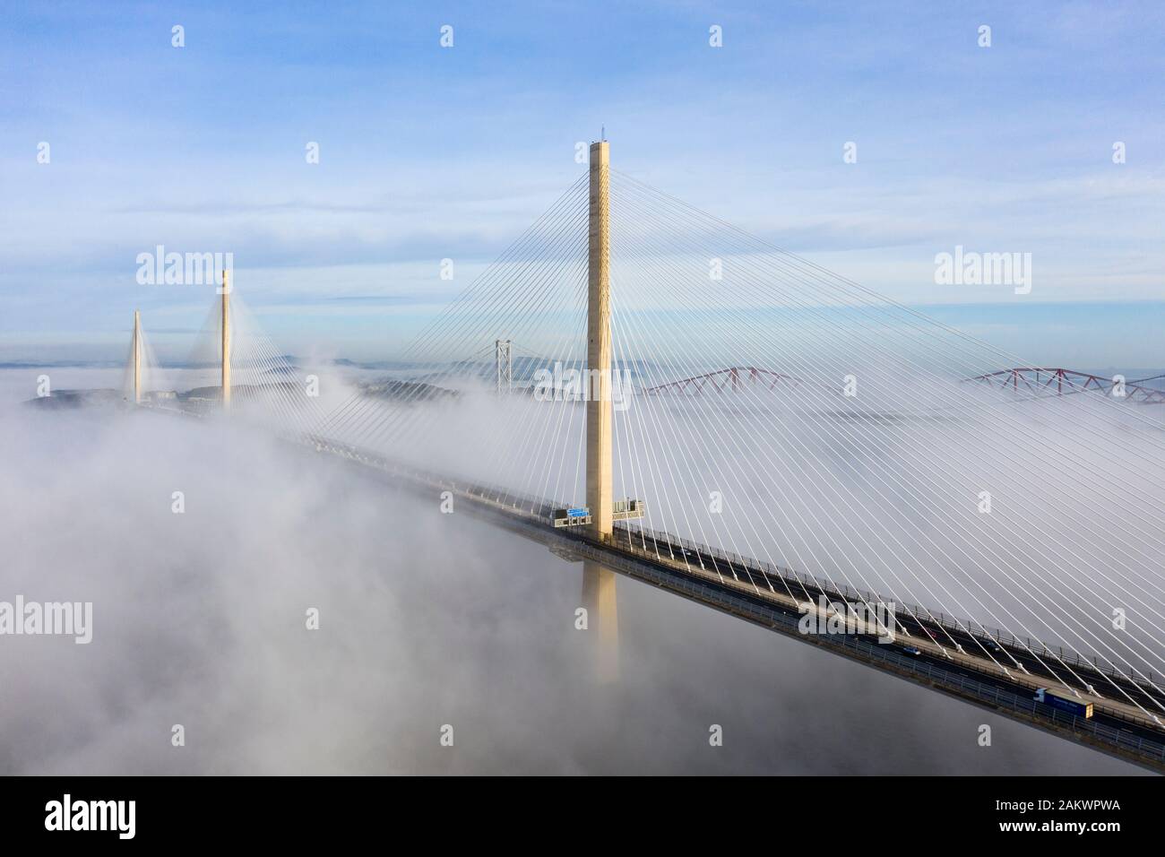 South Queensferry, Ecosse, Royaume-Uni. 10 janvier 2020. Drone image d'un nuage à l'inversion spectaculaire Queensferry Crossing Bridge avec la moitié inférieure du pont enveloppé dans le brouillard, mais la moitié supérieure dans un beau temps ensoleillé. En arrière-plan le pont du Forth et Forth Road Bridge. Iain Masterton/Alamy Live News Banque D'Images