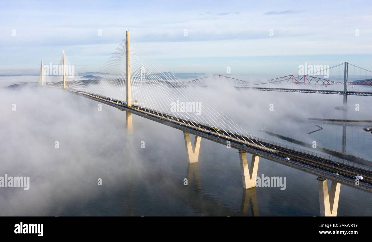 South Queensferry, Ecosse, Royaume-Uni. 10 janvier 2020. Drone image d'un nuage à l'inversion spectaculaire Queensferry Crossing Bridge avec la moitié inférieure du pont enveloppé dans le brouillard, mais la moitié supérieure dans un beau temps ensoleillé. En arrière-plan le pont du Forth et Forth Road Bridge. Iain Masterton/Alamy Live News Banque D'Images