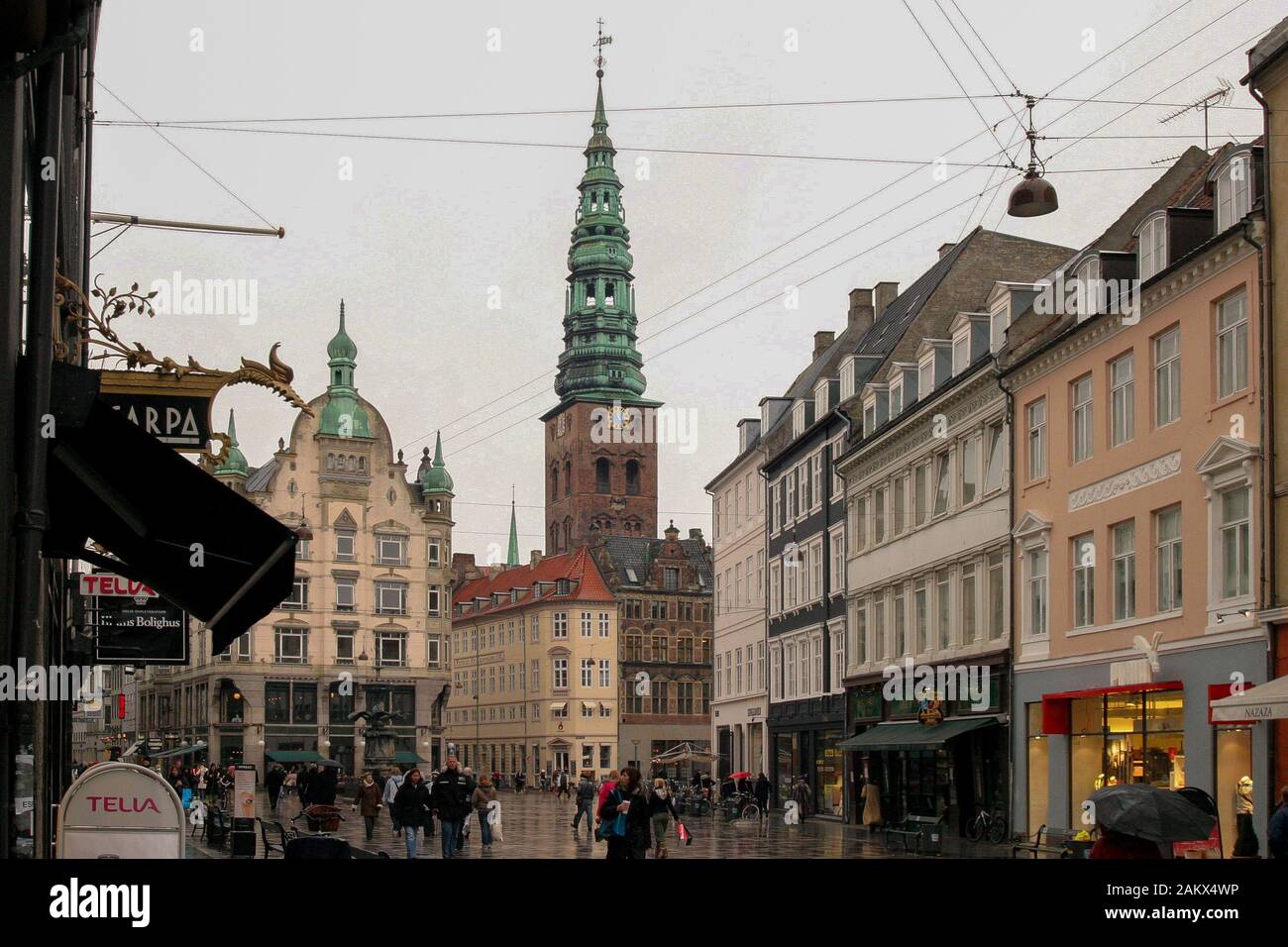 Balades le long de la Shoppers Stroget célèbre zone piétonne de détail sur un jour d'hiver humide avec de la pluie à Copenhague. Banque D'Images