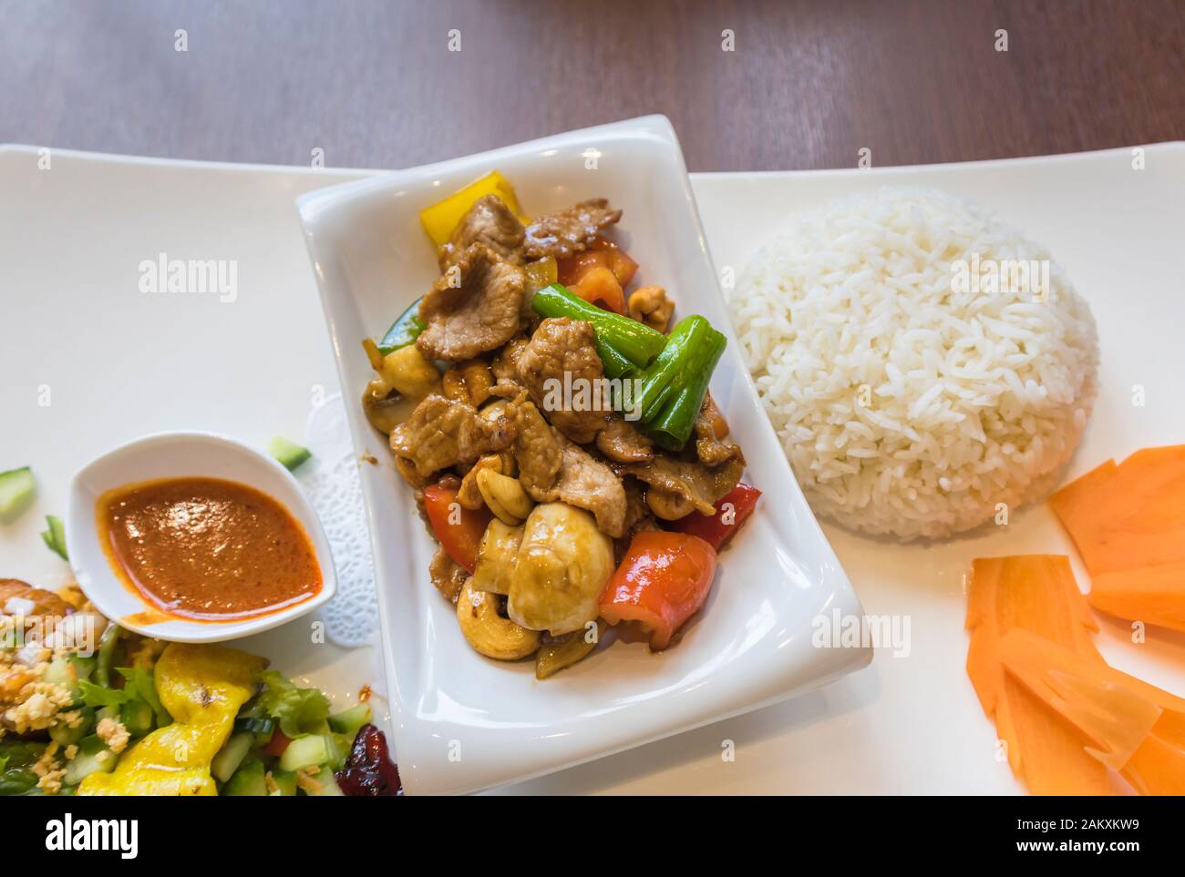 Repas thaï traditionnel, un plat de bœuf sauté de cajou dans un bol avec la Chine sur une plaque avec du riz vapeur et de carotte et garniture de légumes Banque D'Images