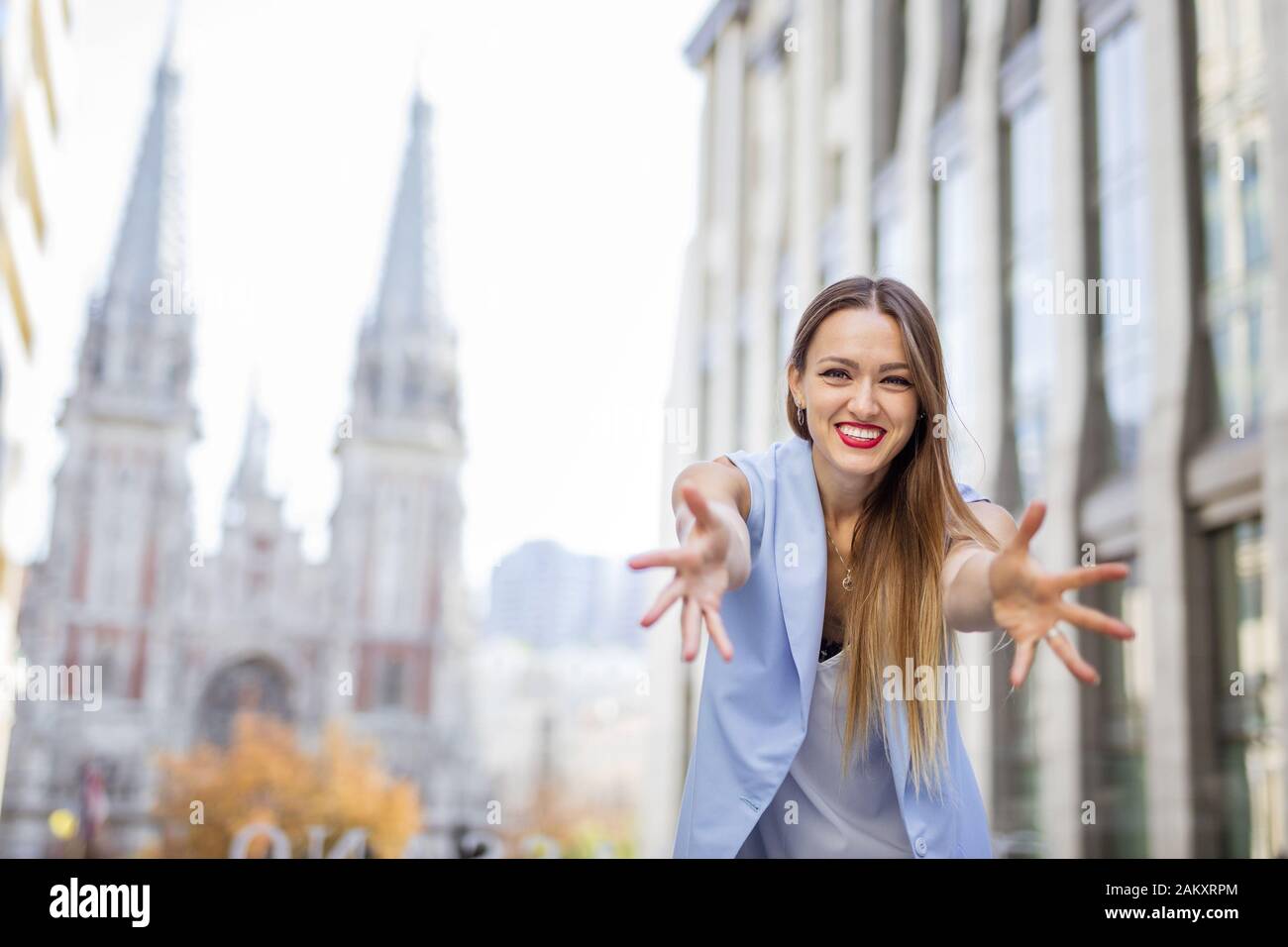 Heureuse jeune femme qui s'étend ses bras dans la joie centre-ville le jour d'automne Banque D'Images