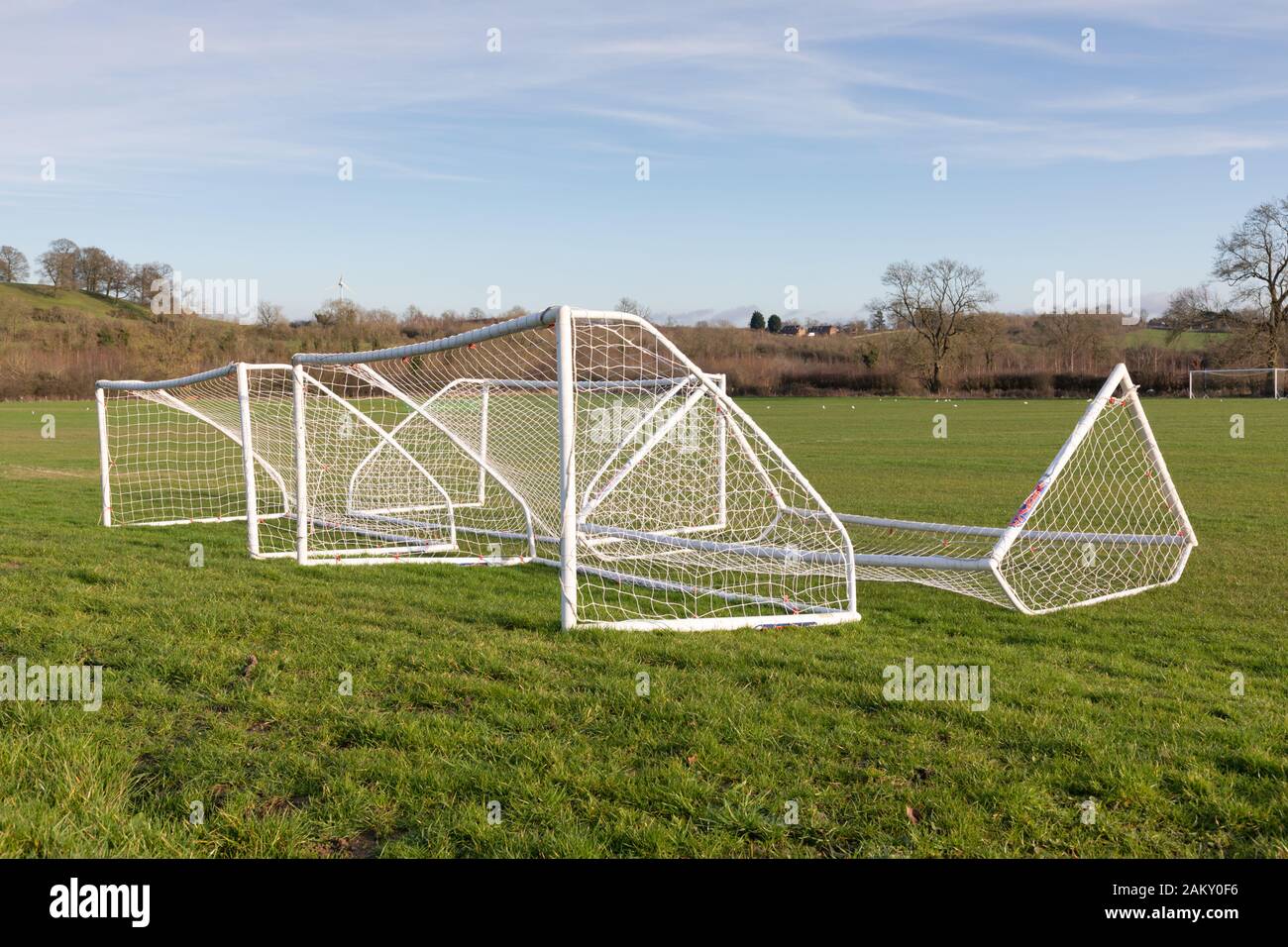 Crick, Northamptonshire, Royaume-Uni: Quatre bouches de football à cinq côtés à cadre blanc et en réseau, qui s'allongés sur l'herbe d'un terrain de jeu en milieu rural. Banque D'Images