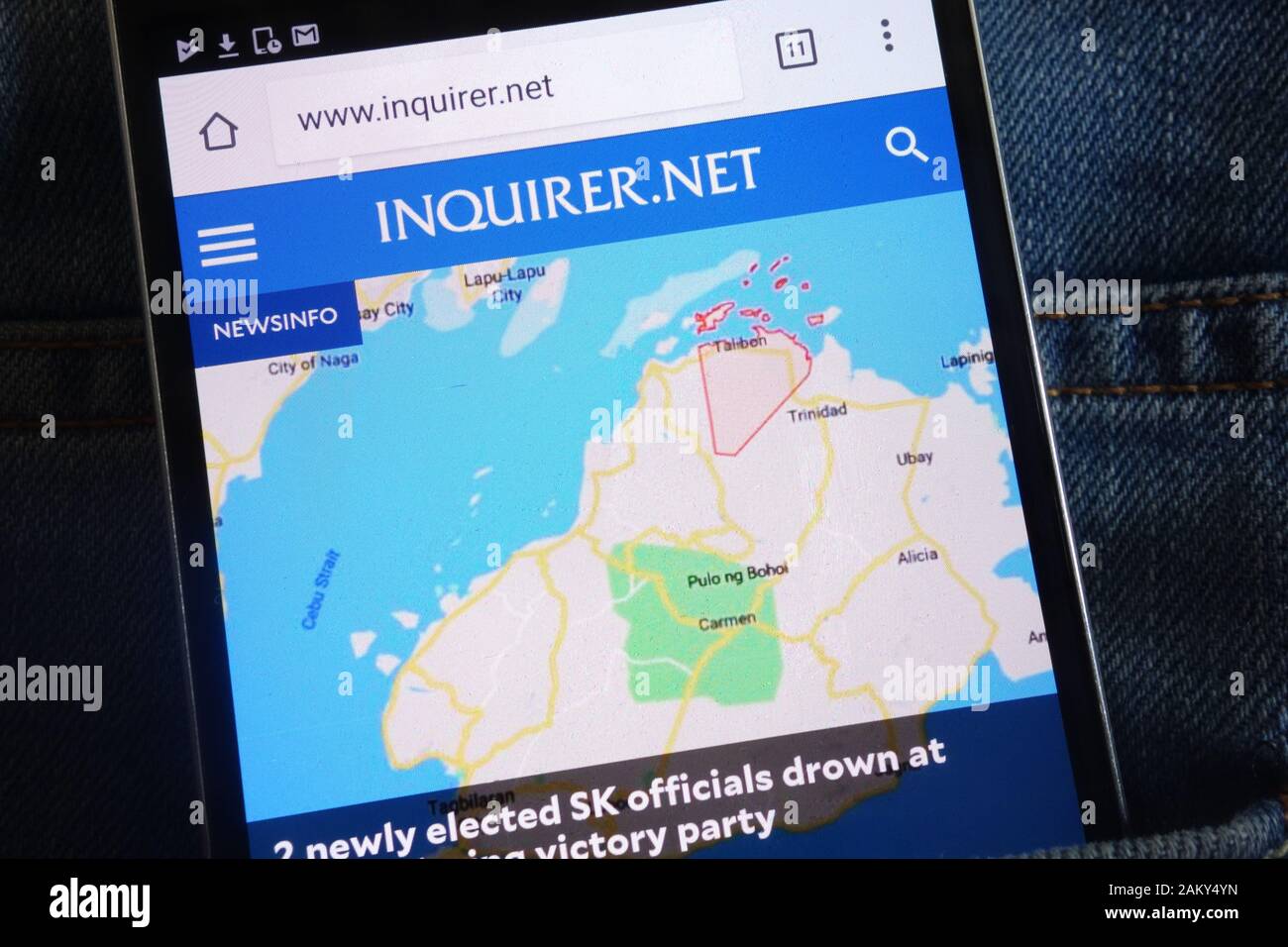 Site web de l'Inquirer (inquirer.net) affiché sur smartphone caché dans la poche de jeans Banque D'Images