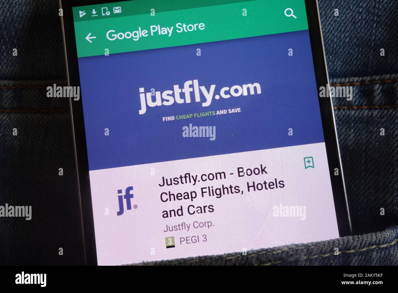 Justfly app sur Google Play Store affiche site web sur smartphone caché dans la poche de jeans Banque D'Images