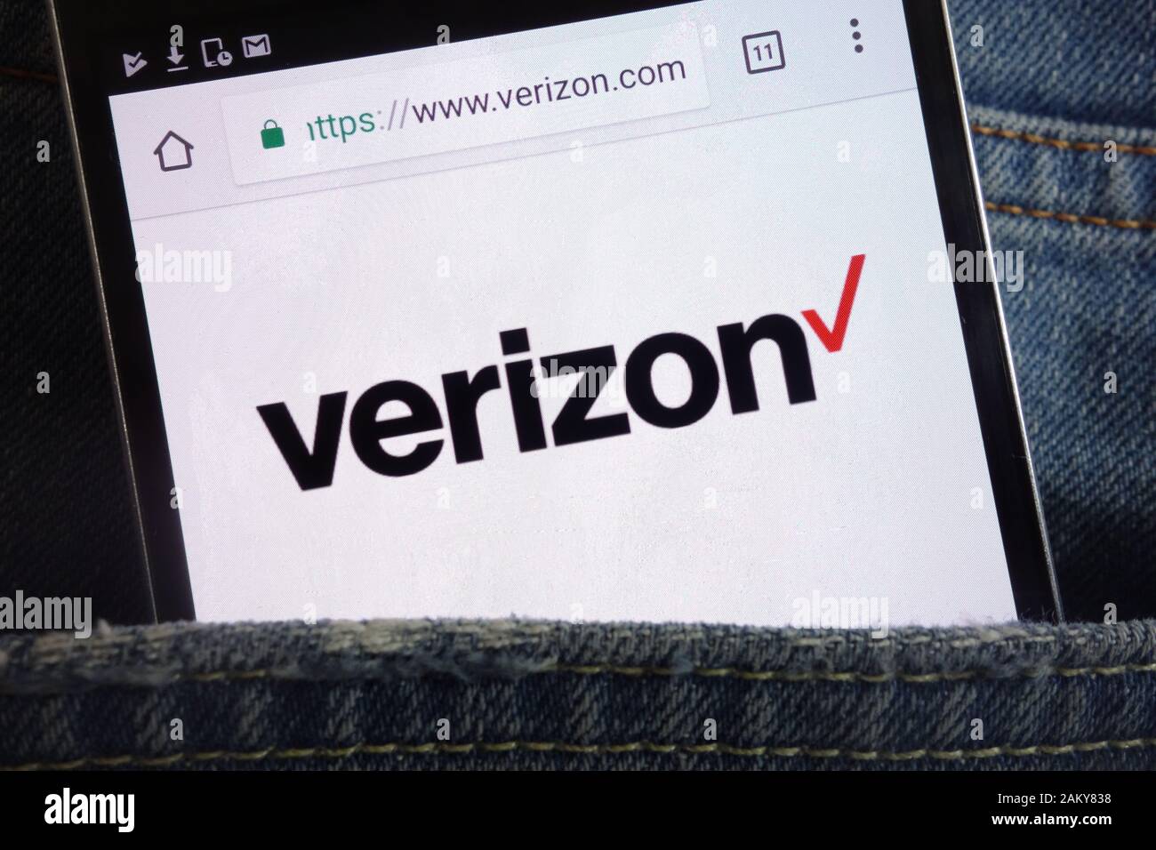 Site Web Verizon affiché sur le smartphone caché dans la poche jeans Banque D'Images