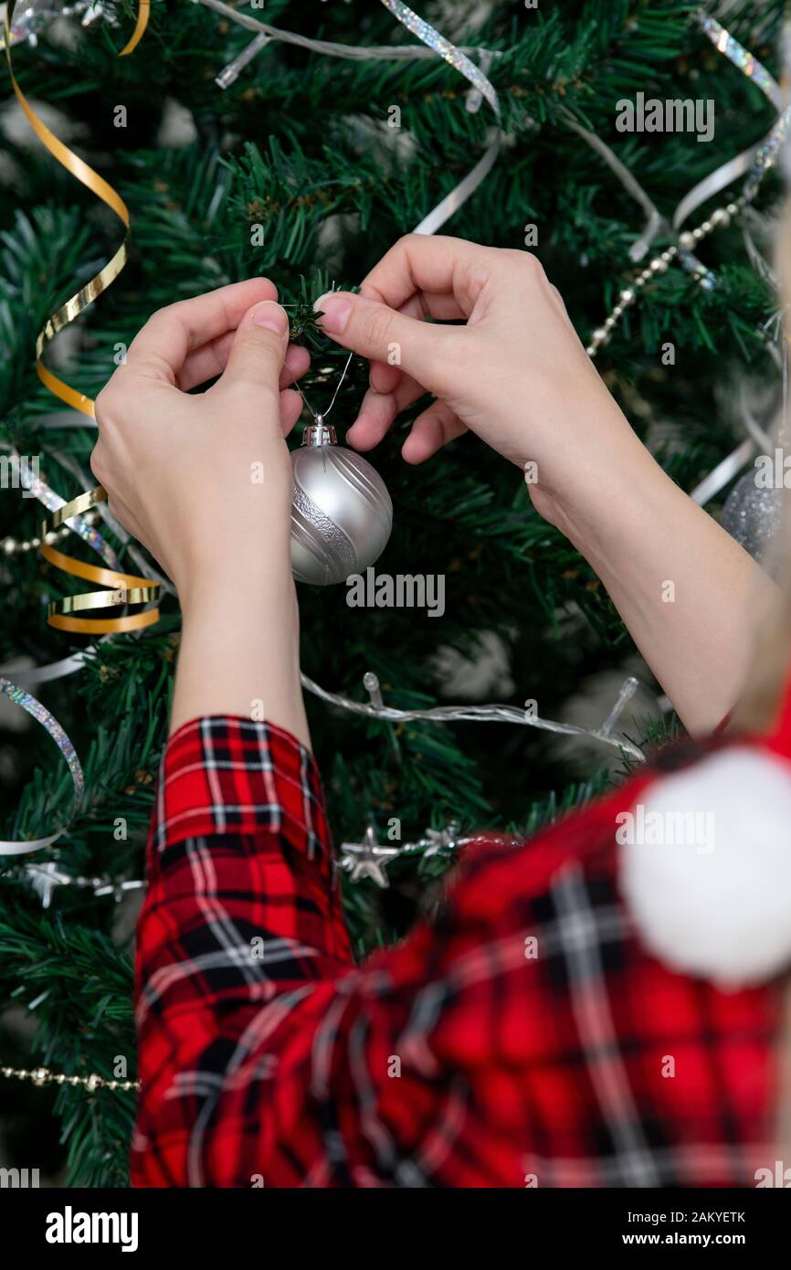 Fille main décorant arbre de Noël Banque D'Images