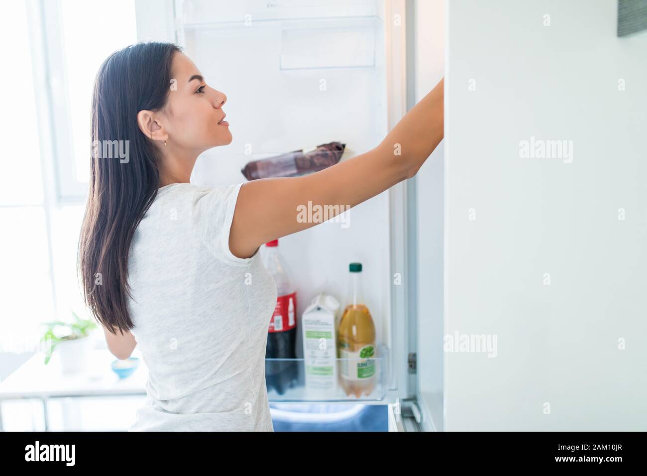 Concept de saine alimentation alimentation .. Belle Jeune femme près du réfrigérateur avec des aliments sains. Fruits et les légumes d'un réfrigérateur Banque D'Images
