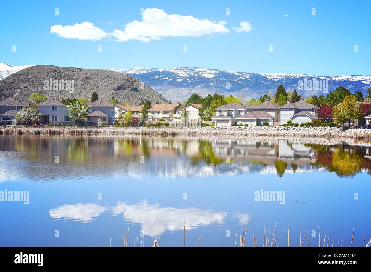 Une banlieue de Reno Nevada sur une journée claire avec un reflet d'un nuage dans un lac et montagnes enneigées à l'arrière Banque D'Images