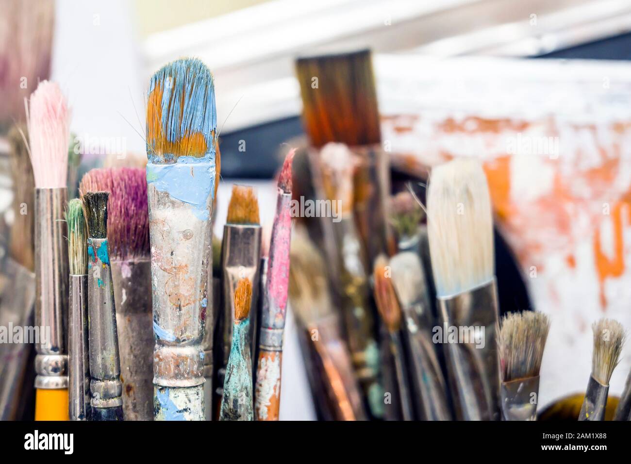 Divers pinceaux artistiques de différentes épaisseurs et formes pour travailler avec de l’huile ou de la peinture acrylique se tiennent dans l’atelier de l’artiste en attendant la création Banque D'Images