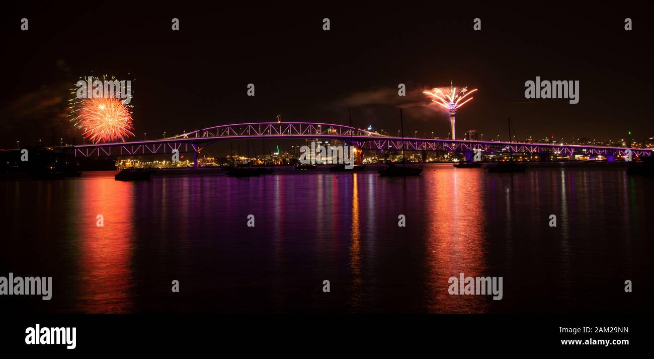 Feux d'artifice d'Auckland pour la célébration du nouvel an avec Harbour Bridge illuminé en violet Banque D'Images