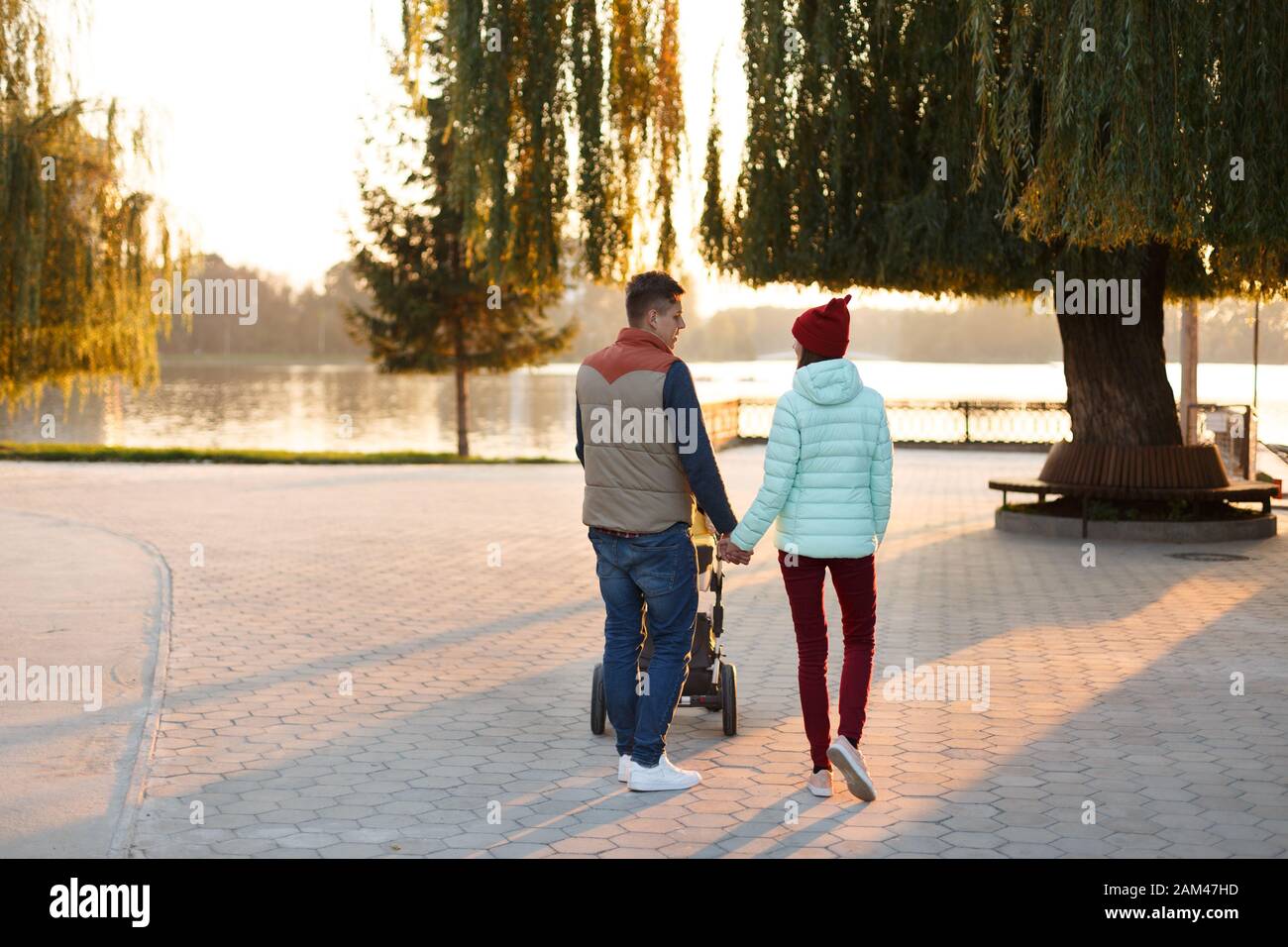 Vue Arriere Du Jeune Couple Aimant Tenant Les Mains Parents Avec Bebe Bebe Dans Le Parc D Automne Concept D Amour De Parente De Famille De Saison Et De Personnes Photo Stock Alamy