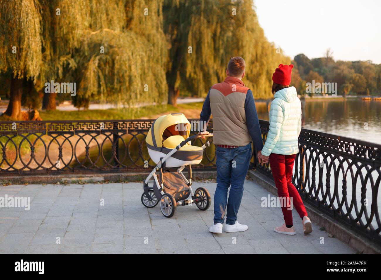 Vue Arriere Du Jeune Couple Aimant Tenant Les Mains Parents Avec Bebe Bebe Dans Le Parc D Automne Concept D Amour De Parente De Famille De Saison Et De Personnes Photo Stock Alamy