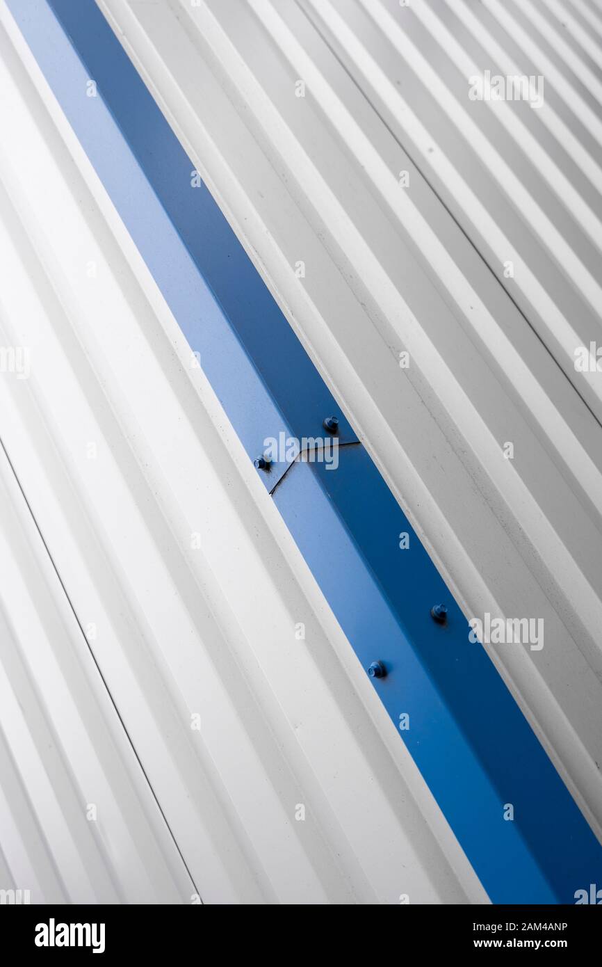 Plaques ondulées métalliques sur un bâtiment avec un bleu metal coins. Toit ondulé en aluminium blanc pour mur ou sur une des feuilles et de l'industrie des usines Banque D'Images