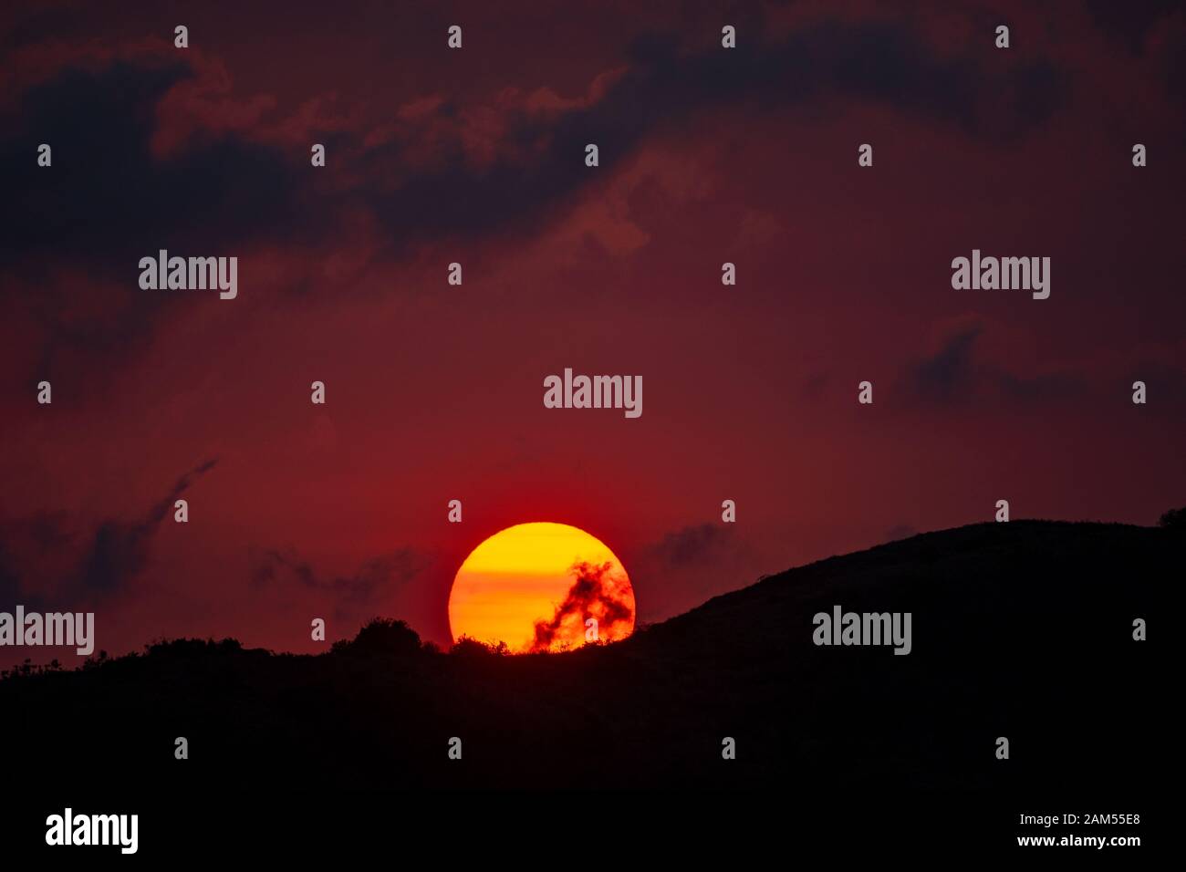 Coucher de soleil sur Whitsunday Island, Queensland avec des couleurs exagérées par la fumée des feux de brousse à proximité Banque D'Images