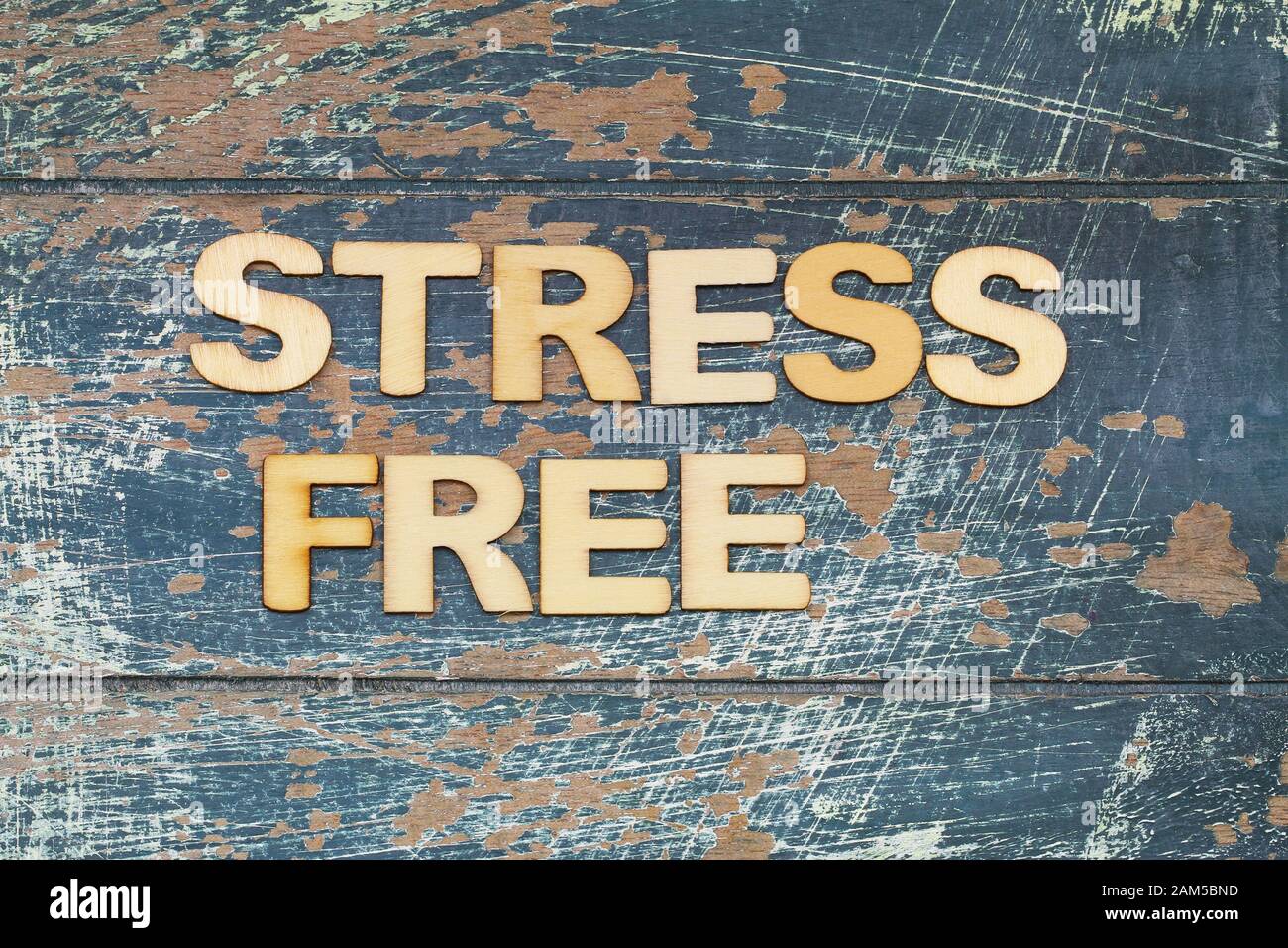 Sans stress écrit avec des lettres en bois sur la surface rustique bleue Banque D'Images
