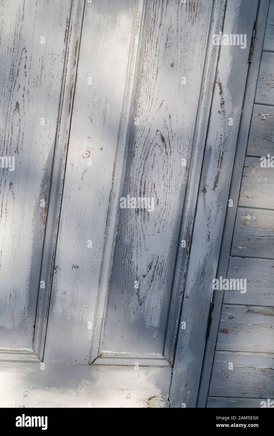 La peinture abîmé s'écaille d'une vieille porte en bois.Peinture écaillée, craquelures de peinture, vieille peinture, vieille porte décolorée par le temps. Banque D'Images